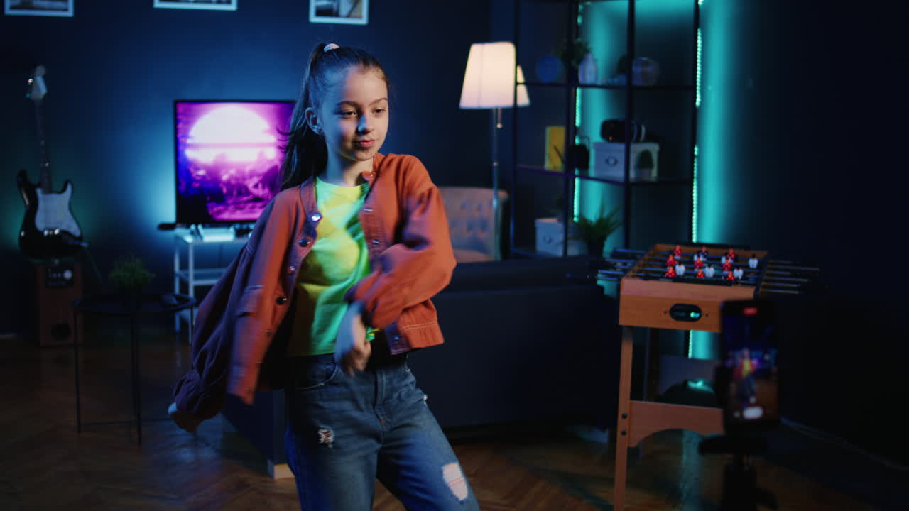 niño sonriente participando en una tendencia de baile viral filmando un video con el teléfono conectado al estabilizador de trípode