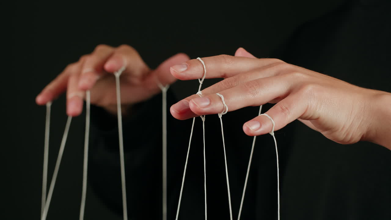 Close-up of Human Hands Manipulating White Strings