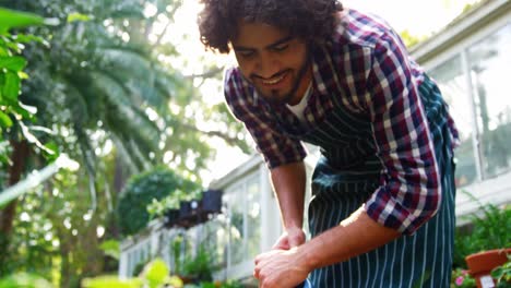 Man-watering-plant-with-watering-can