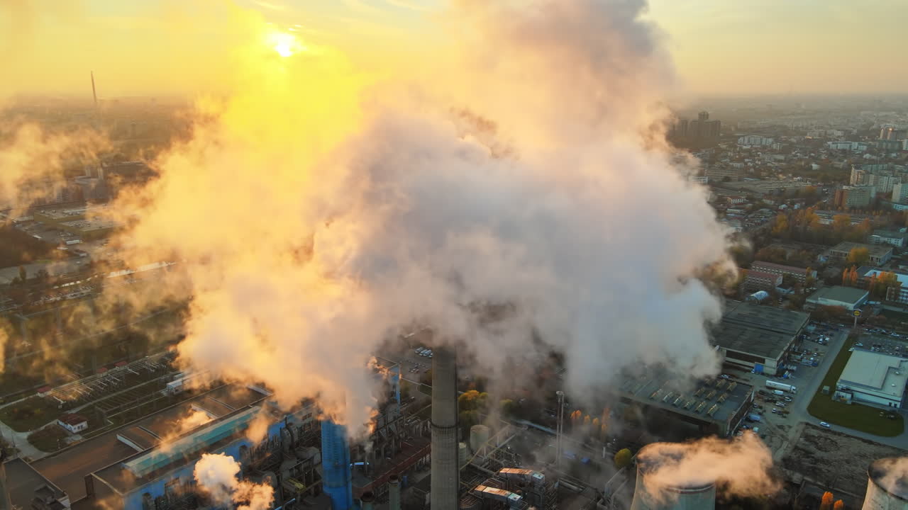 Power station with a lot of tubes and facilities in Bucharest at sunset, a lot of foam. Cityscape, view from the drone flying through the foam, Romania
