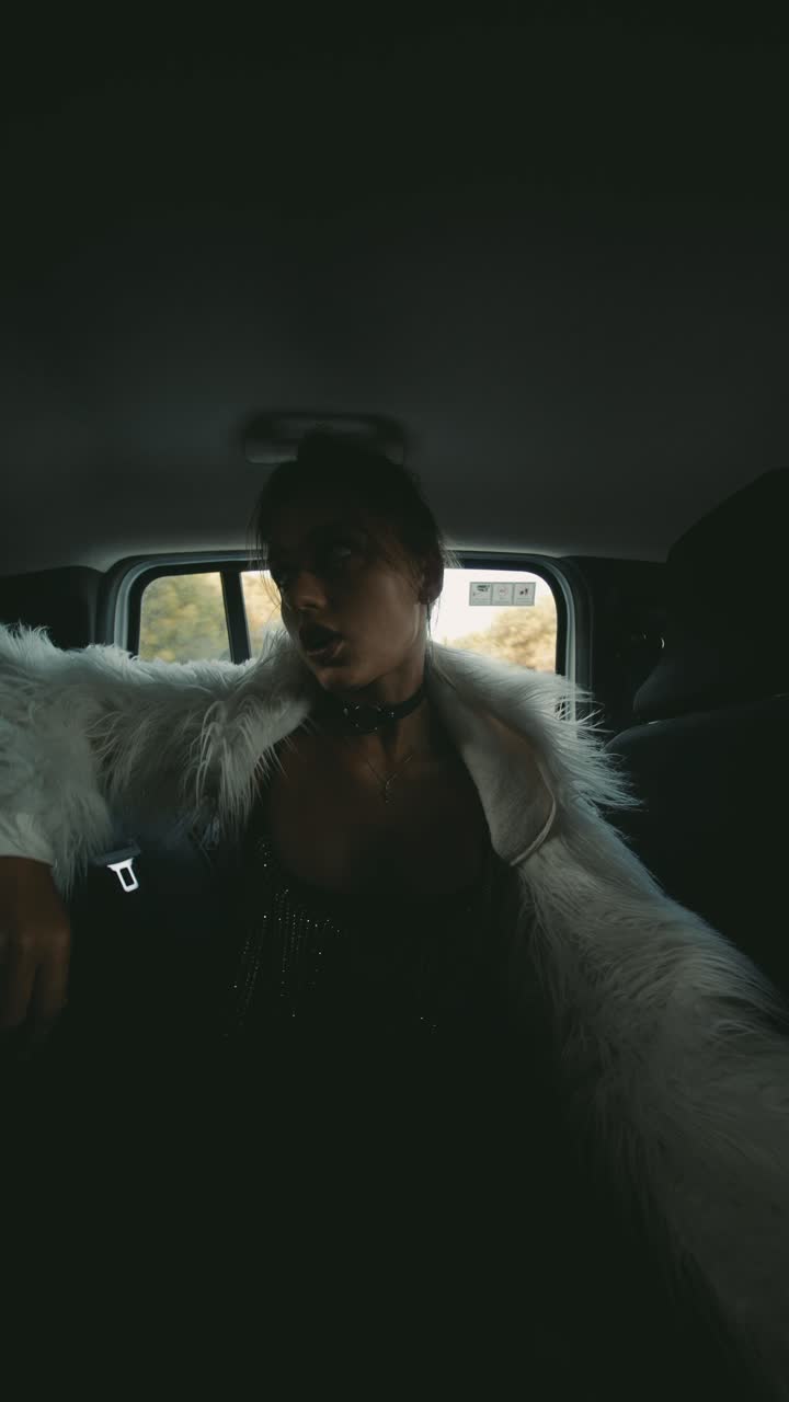 A woman in a fur coat in a car