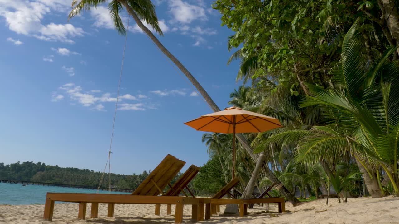 Lettini da spiaggia con ombrellone su una spiaggia di sabbia bianca