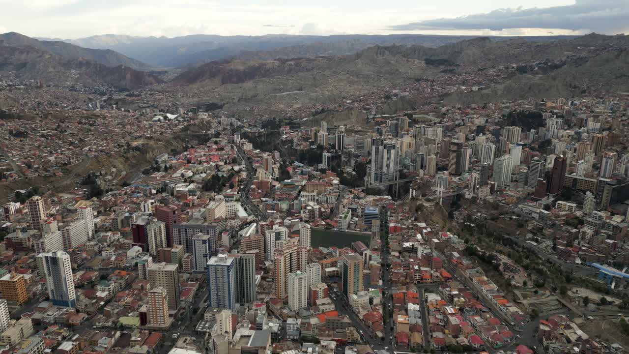 drones aéreos vuelan sobre la paz, bolivia, estadio hernando siles, ciudad metropolitana más multitudinaria, casas, rascacielos y cordillera de la cordillera andina en el fondo