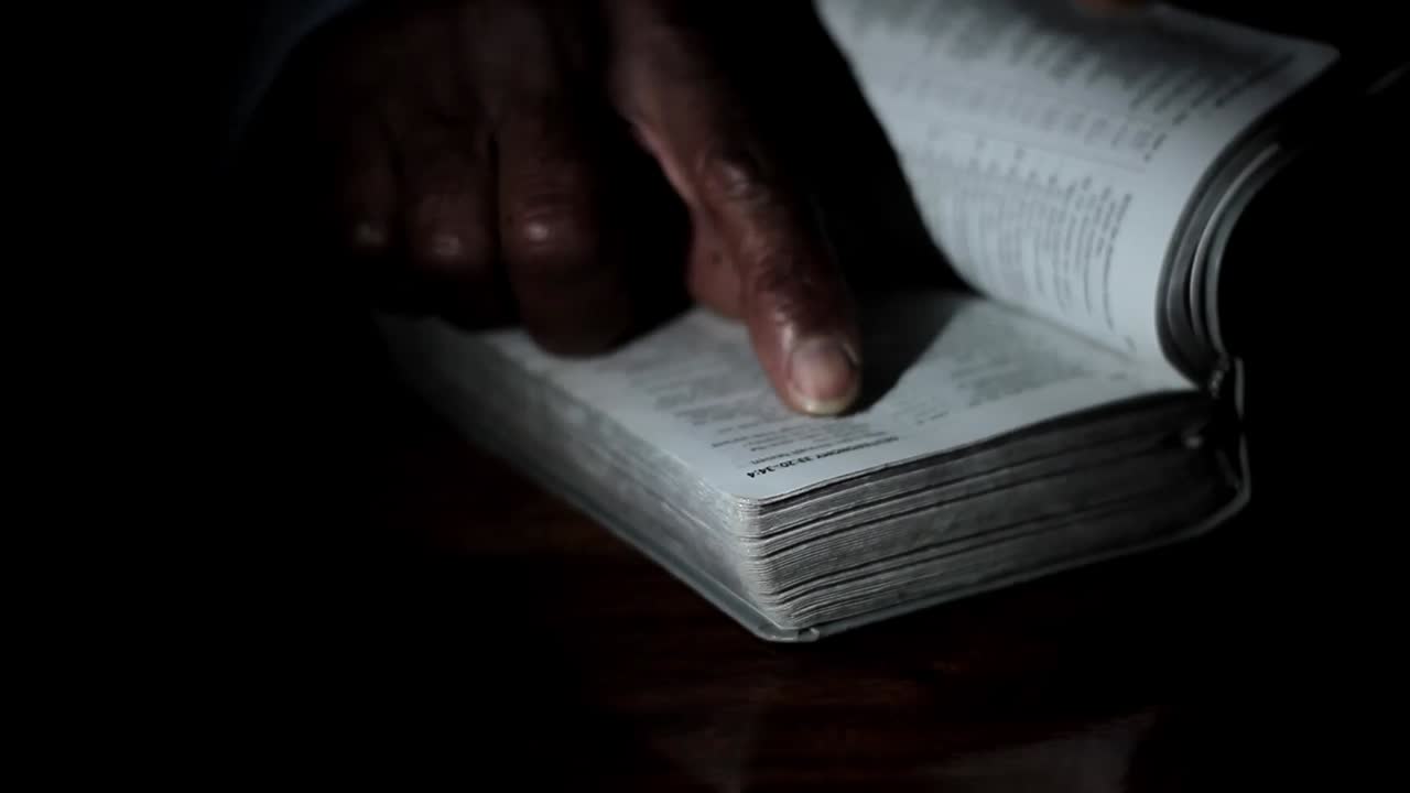 praying to God with hand on bible black background with people stock footage