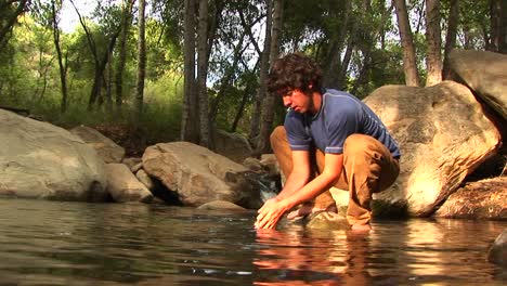 Lowangle-Of-A-Hiker-Washing-His-Face-In-A-Montaña-Pool