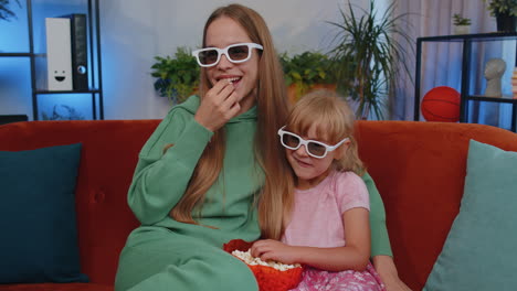 girls friends siblings watching favorite tv show movie and eating popcorn, sitting on home sofa