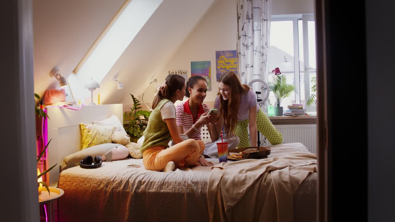 십대 소녀들이 침실에서 함께 시간을 보내고 있습니다.