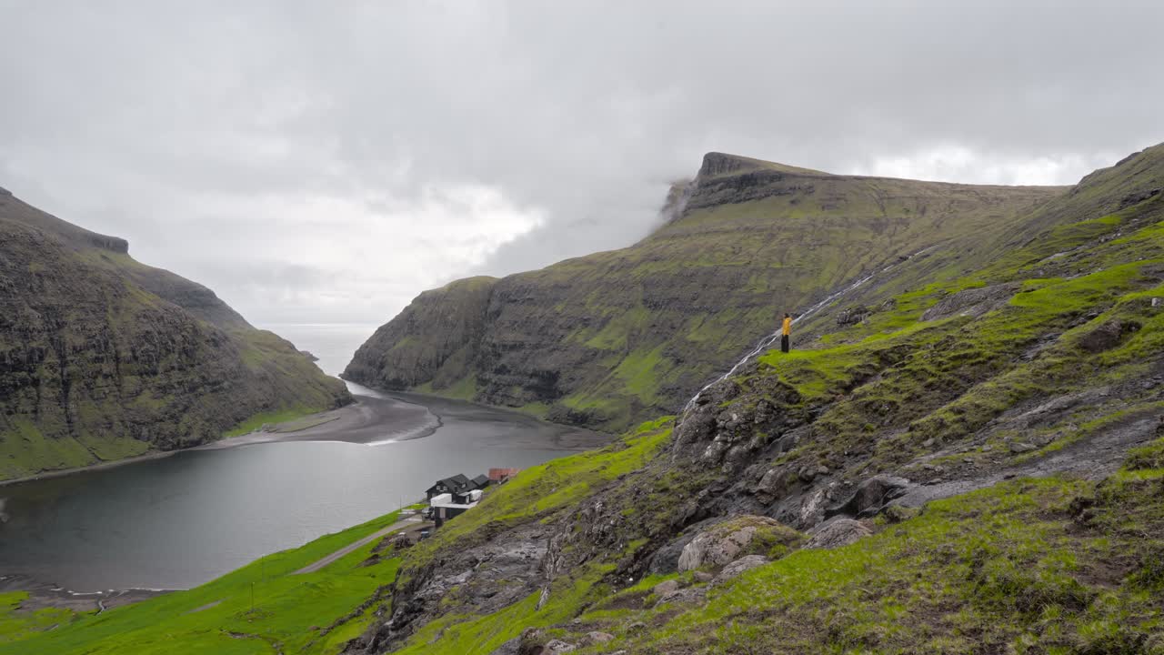 una vista panorámica de saksun, las islas feroe, con acantilados verdes, un valle y vibraciones serenas