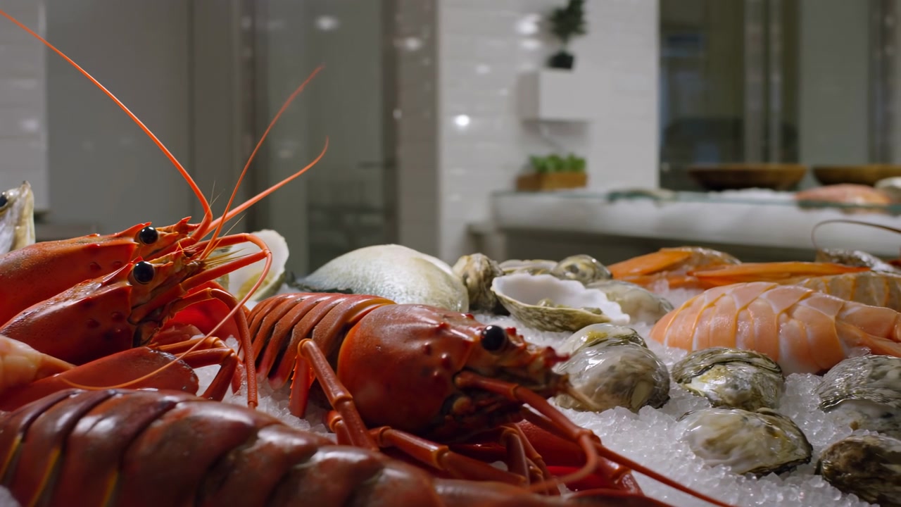 Lobster And Oysters On Ice Arranged On Crushed Ice At Upscale Restaurant Counter, Plump Shrimp And Prawn
