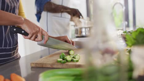 video of hands of african american couple preparing meal together in kitchen