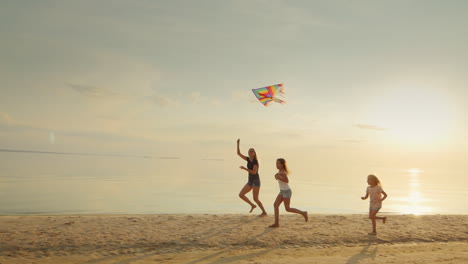 mother with two daughters playing on the beach with a kite the fun run together happy childhood