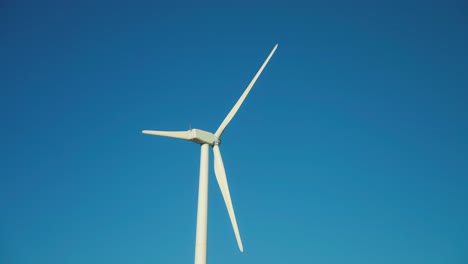 isolated wind turbine with clear blue sky on the background