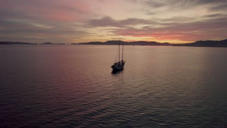 Silhouette-Eines-Einzigen-Bootes-Und-Berge-Bei-Sonnenuntergang,-Malaysische-Küste