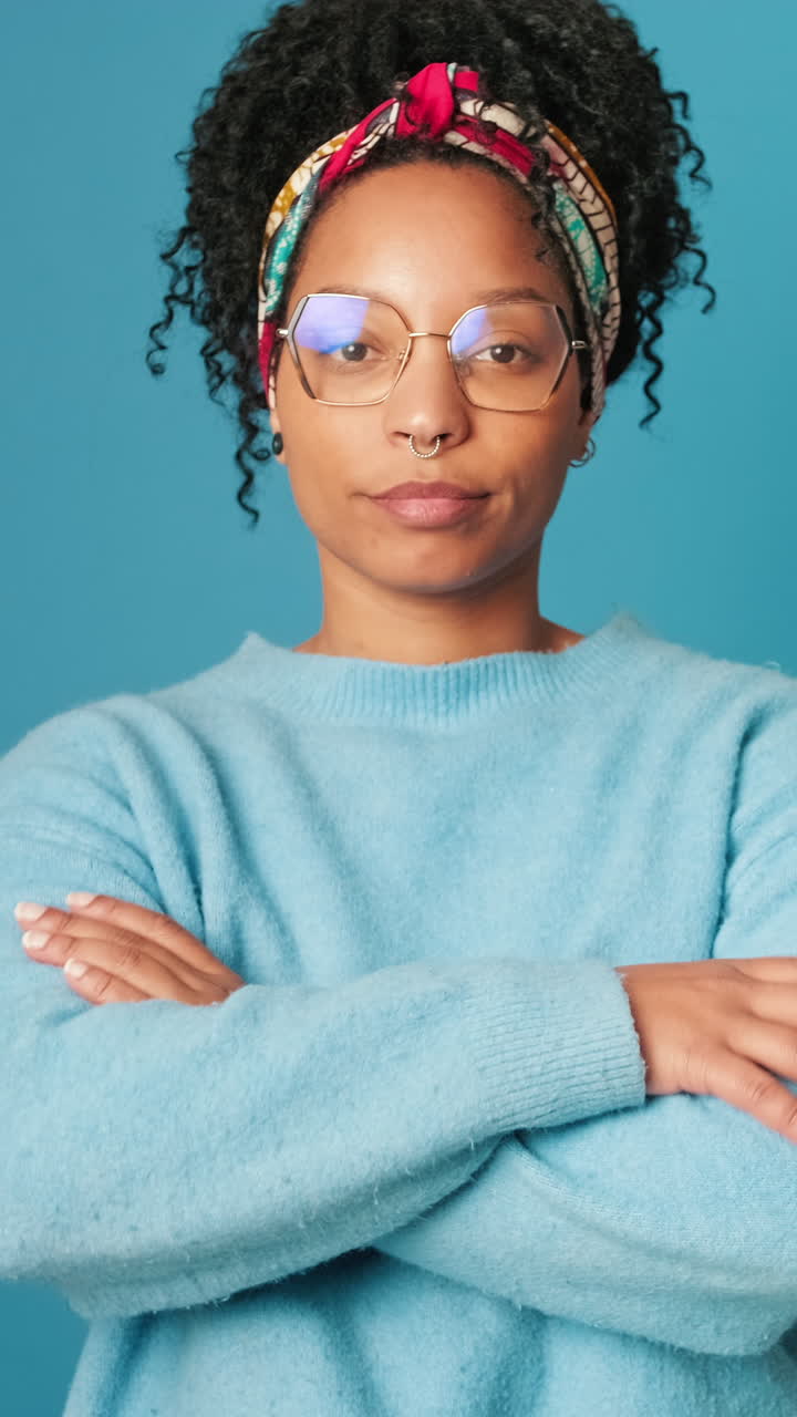 Young Woman with Curly Hair and Glasses Opening Eyes and Crossing Arms