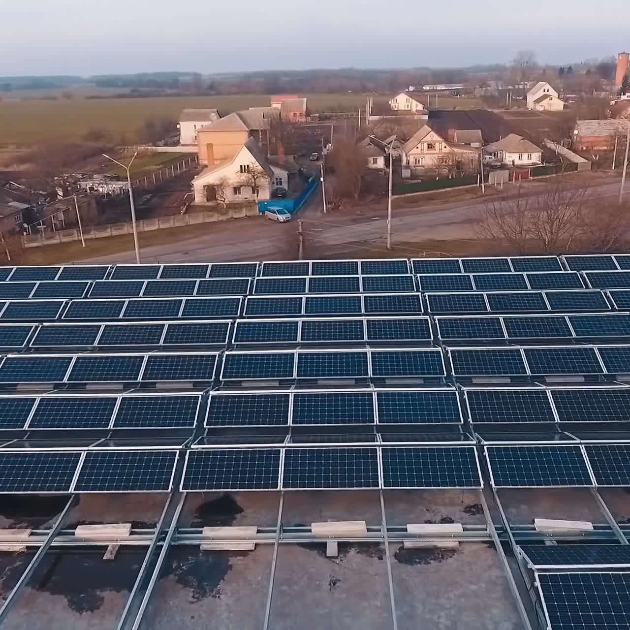 Top aerial view of solar farm on roof. Sunny batteries for renewable energy on the building in the coundtryside. Alternative energy.