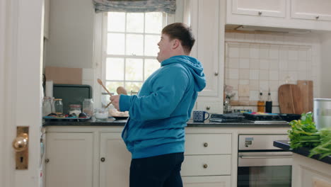 happy-teenage-boy-with-down-syndrome-dancing-in-kitchen-having-fun-celebrating-funny-dance-enjoying-weekend-at-home