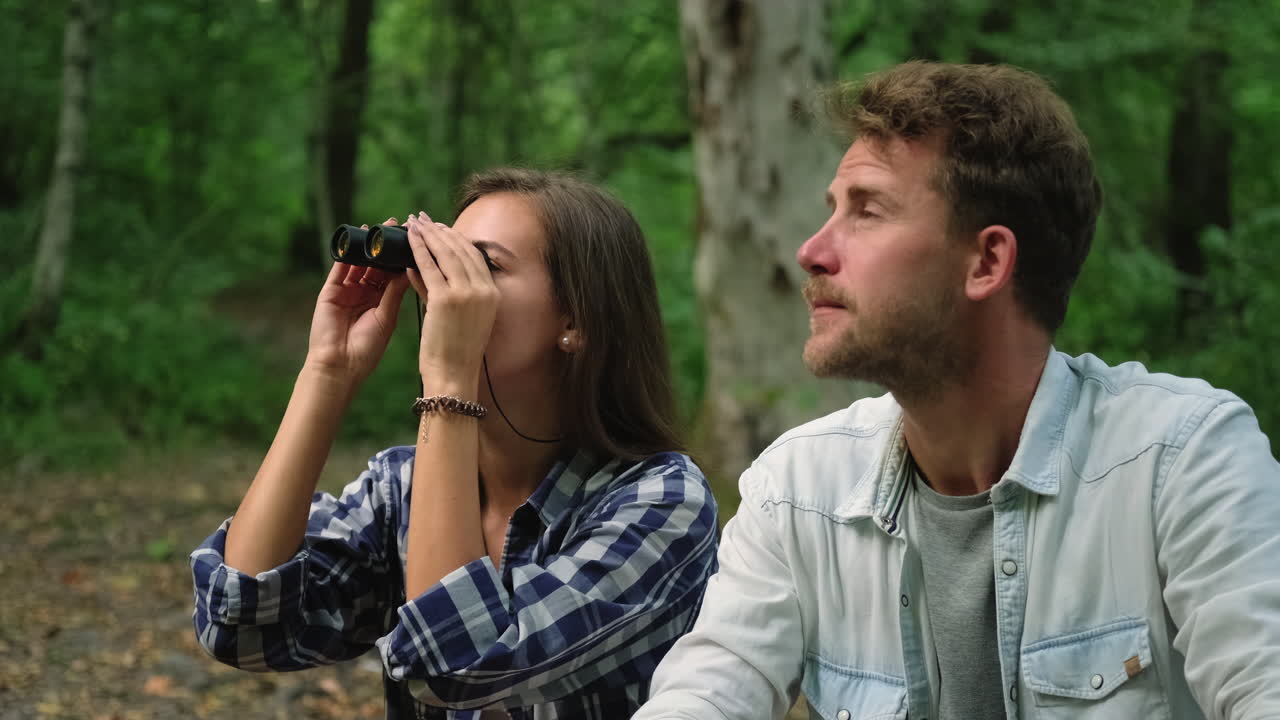 pareja usando binoculares en el bosque