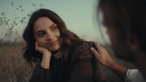 a man offers a comforting touch to a thoughtful woman outdoors