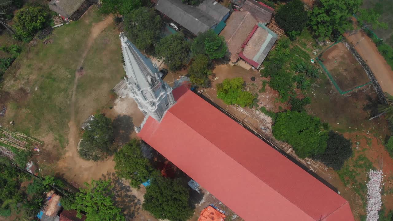 Pemandangan udara Gereja Katolik Giao Xu Bach Xa di Ben Den, Tuyen Quang, Vietnam di samping perairan sungai yang tenang