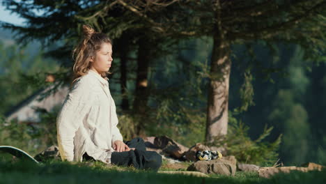 mujer joven estirándose con postura de yoga en las montañas