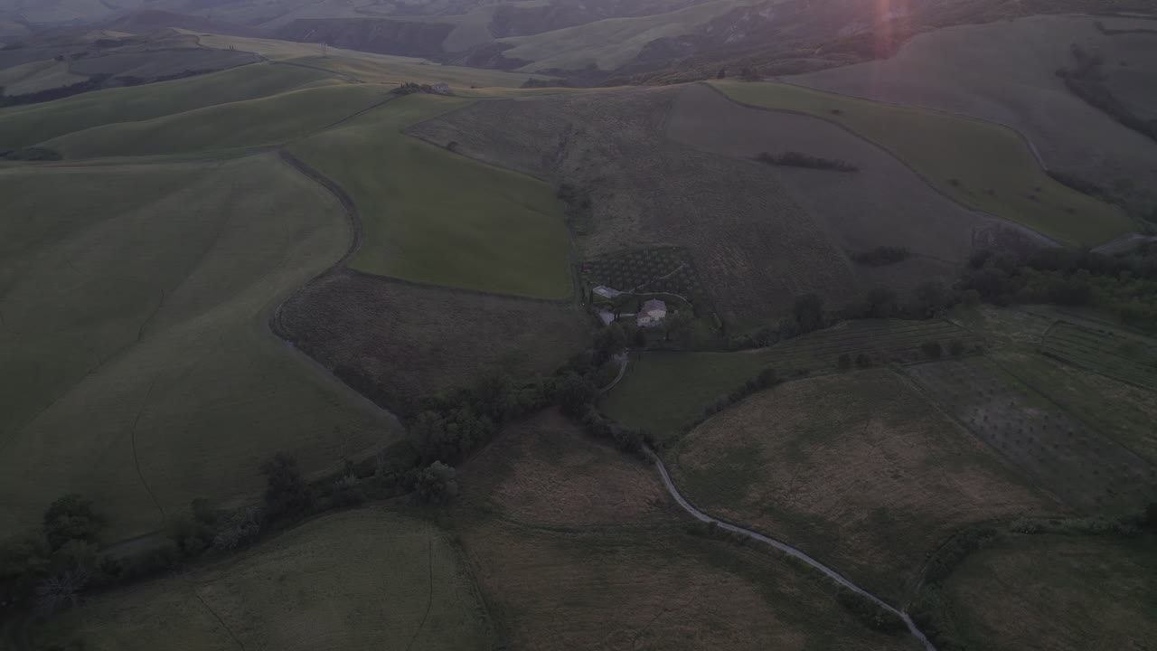황금빛의 저녁 빛 속의 언덕과 계곡이 있는 스카니아의 경치적인 풍경의 드론  이탈리아의 도르시아에 있는 산 카시아노 데이 바그니 (san casciano dei bagni) 에서 해가 지는 동안