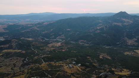 A-drone-aerial-of-a-valley-and-reveal-of-a-stone-covered-peak