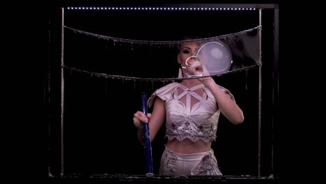 young girl does tricks with soap bubbles. she blows a pipe with bubbles of smoke