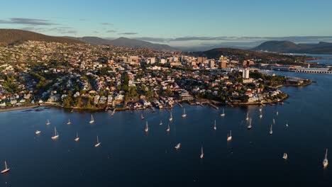 aerial view of hobart city and the boats on the water of the river derwent at sunset.