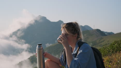 woman enjoying a drink on a mountain top