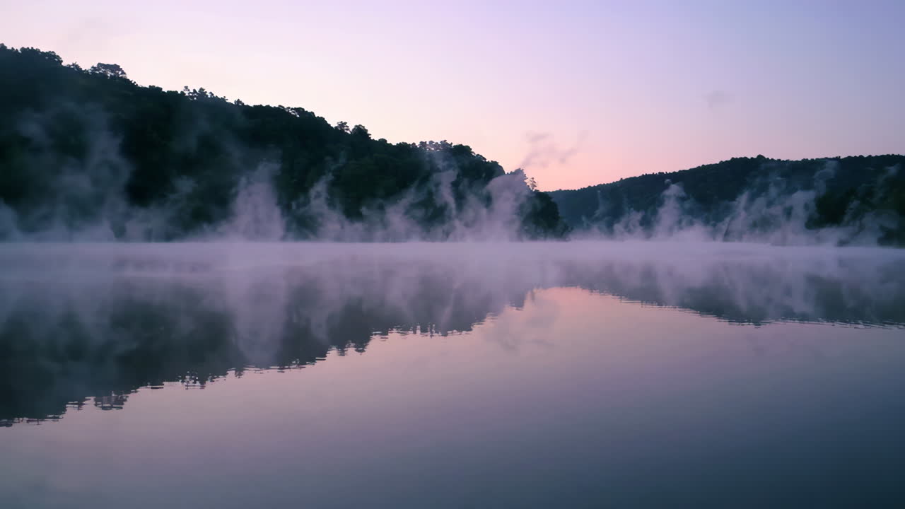 조용한 호수 위 의 안개 가 가득 한 해가 뜨는 것