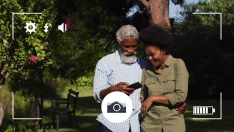 animation of camera digital interface over african american man and woman with smartphone