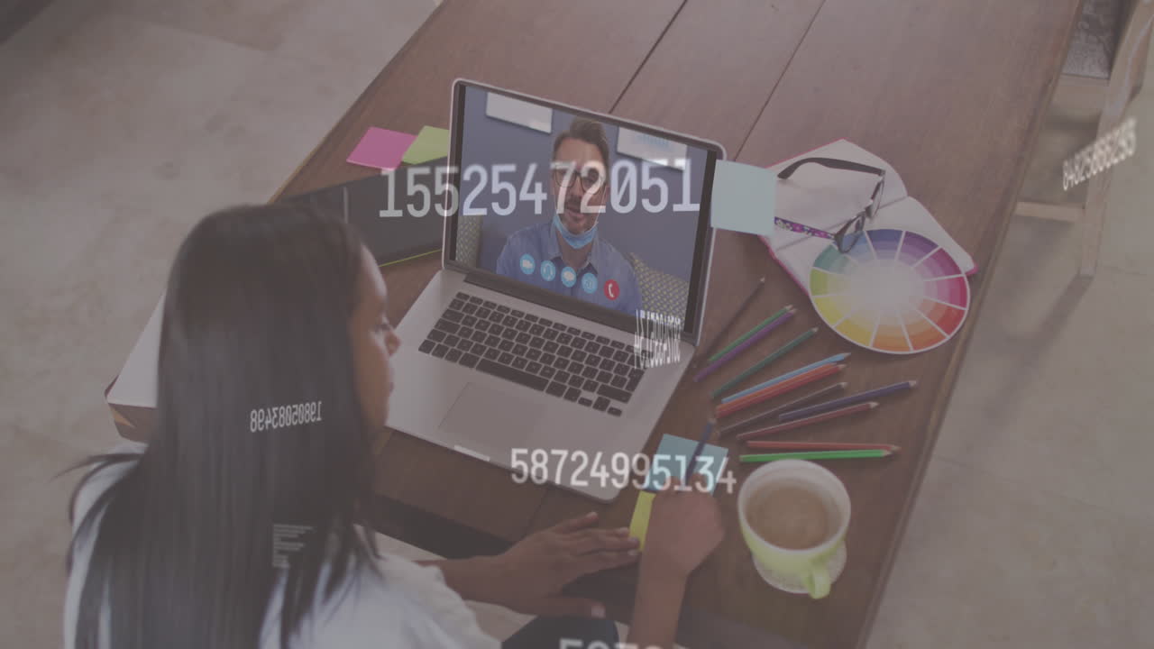 Multiple changing numbers against woman having a video call with male colleague on laptop at office