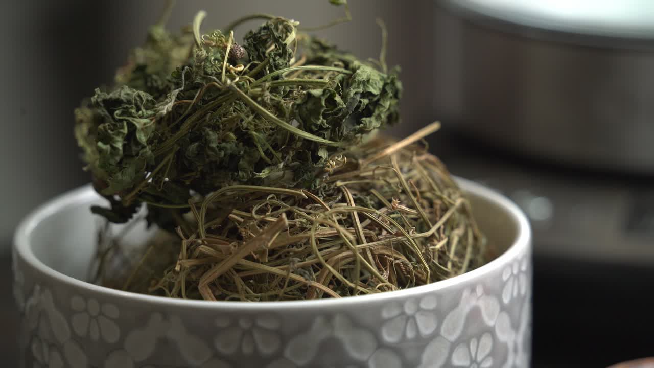 컵에 차 잎의 좋은  러세 케랄라 쓴 멜론 식물과 케랄라 포도나무에 매달려 허브 건강한 차를 만드는 데 사용됩니다.