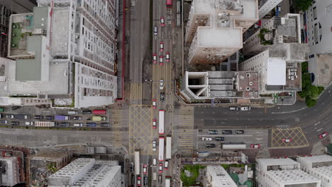 atasco de tráfico en la encrucijada hong kong, zoom en foto aérea de arriba hacia abajo, edificios residenciales altos, primer plano, coches, autobuses, taxis, transporte público, durante el día, cruce de cebras, intersección, calle, esquina, techo