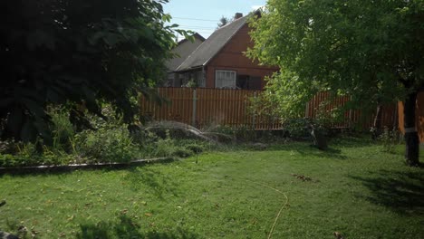 grass sprinkler spins playfully in the garden of a summer house push in
