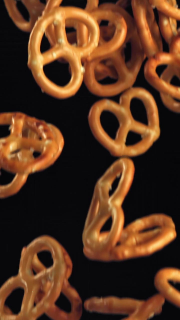 Pretzel salati che cadono al rallentatore su sfondo nero