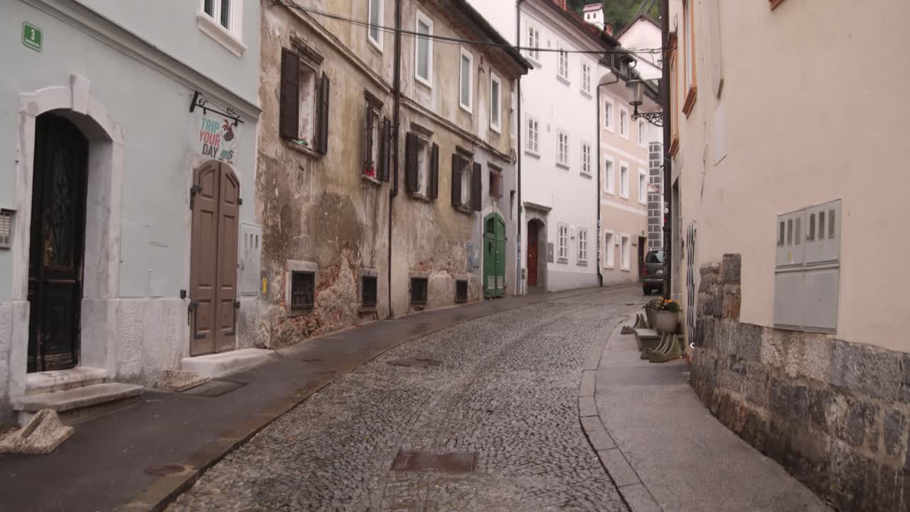 Charming narrow street in Ljubljana, Slovenia, lined with historic buildings and rustic facades.