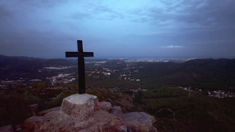 una cruz de madera en la cima de una montaña al crepúsculo