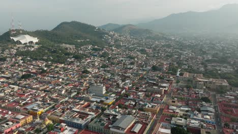 drone: high altitude reveal tilt up shot of downtown oaxaca in the early morning on a sunny summer day