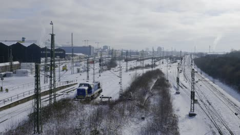 railways on a snowy day with a train standing in it