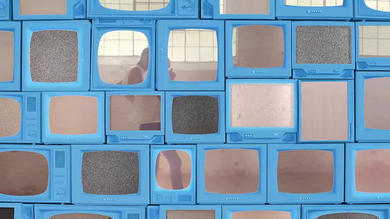 壁一面に並んだレトロなテレビに、グリッチビデオや砂嵐が映し出されています。