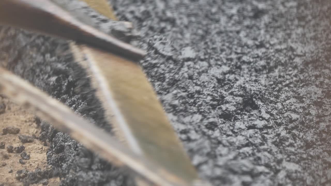 Close Up Shot of Hot Gravel Being Raked Over Pothole