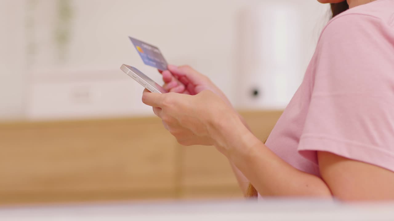 mujer joven asiática usando tarjeta de crédito para pagar compras en línea en el teléfono móvil. escribiendo a mano el número de tarjeta de crédito a la compra de ropa de la tienda en línea de internet. concepto de tecnología de pago digital