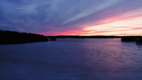 aerial drone footage of stunning frozen lake scenery by golden hour after sunset