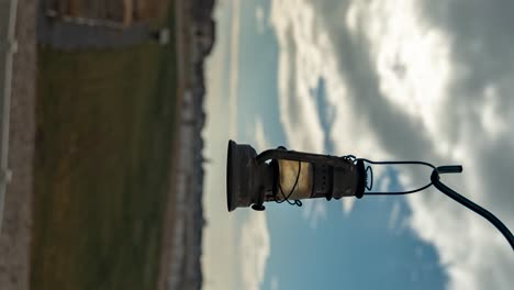 a vintage lantern with a cloudscape in the background - parallax motion time lapse in vertical orientation