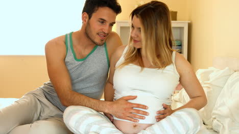 Happy-couple-sitting-in-bed