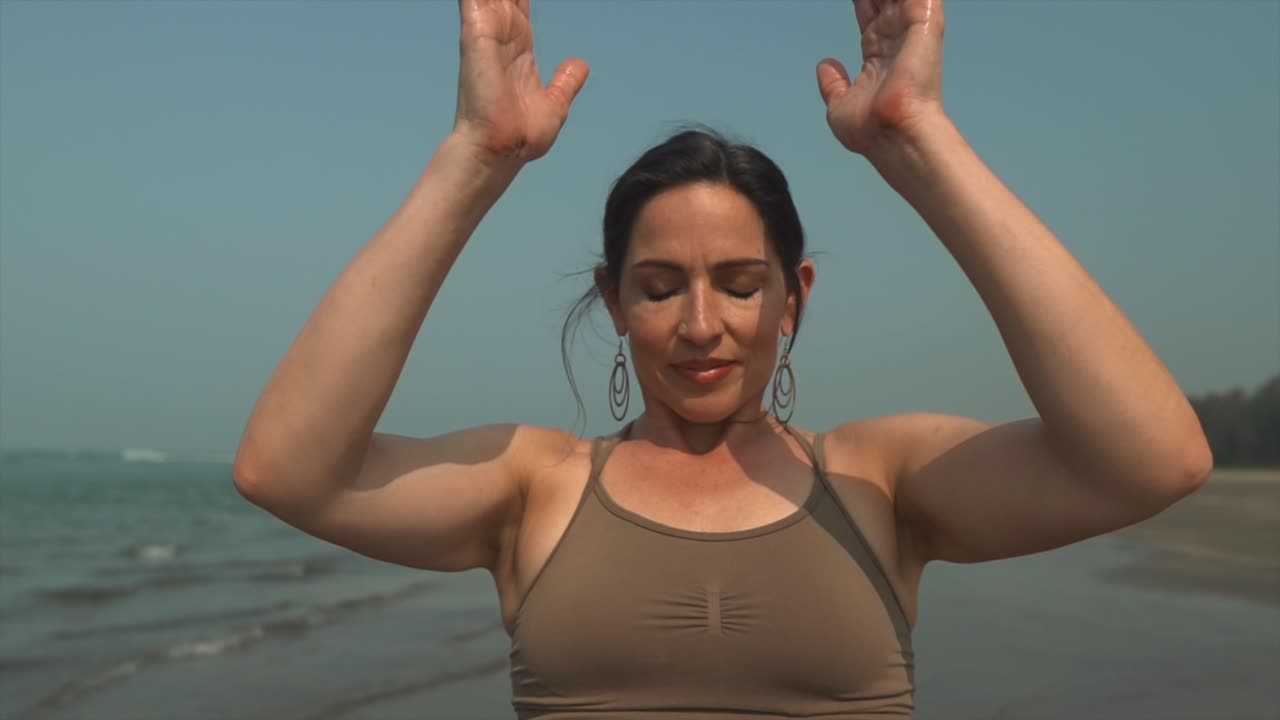 namaste mujer morena trabajo de respiración profunda, meditando yoga en la costa de la playa