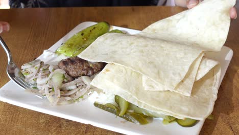 turkish food plate with kebab, pita, and vegetables