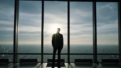 man contemplating a cityscape view from a skyscraper window