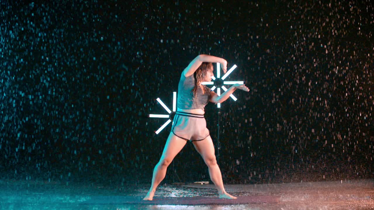 Female dancer martial arts movement in the rain, slow motion effect